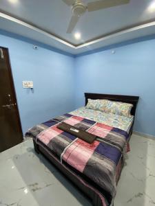 a bed in a room with a blue wall at Millennia service apartments in Hyderabad
