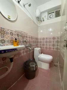 a bathroom with a white toilet and a sink at Millennia service apartments in Hyderabad