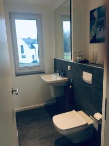 ein Bad mit einem WC, einem Waschbecken und einem Fenster in der Unterkunft Exklusives FERIENHAUS im Yachthafen Peenemünde - mit Seeblick in Peenemünde