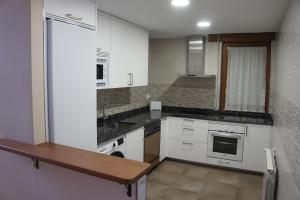 a kitchen with white cabinets and a wooden counter top at Mirador de San Marcos in Soria
