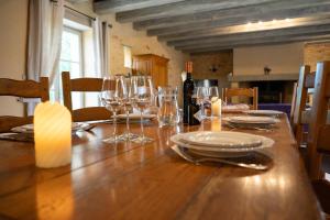 einen Tisch mit Weingläsern und eine Flasche Wein in der Unterkunft Villa en pierre 10 pers, piscine chauffée in Saint-Amand-de-Coly