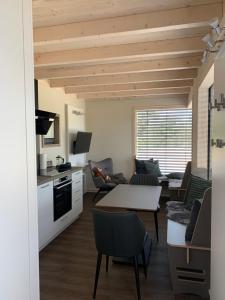 eine Küche und ein Wohnzimmer mit einem Tisch und Stühlen in der Unterkunft Tiny Haus Park Fritzlar in Fritzlar