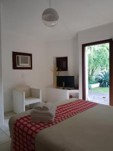 1 dormitorio con 1 cama con manta roja y blanca en Les Jardins de Rio Boutique Hotel, en Río de Janeiro