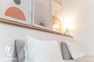 estante sobre una cama con almohadas blancas en WeeklyHouse Silto Crete - Vacation STAY 69850v en Otsu