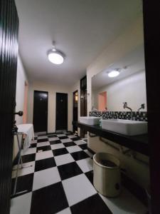 a bathroom with a black and white checkered floor at KzaZenDF CamaeCafé AsaSul in Brasilia