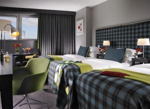a hotel room with two beds and a desk and chairs at Clayton Hotel Limerick in Limerick