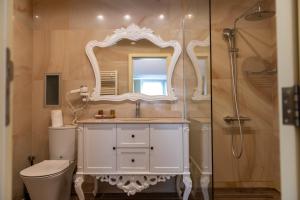 a bathroom with a toilet and a sink and a shower at ATLAS HOUSE Luxury Suites in Plovdiv