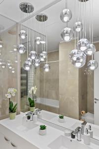 ブカレストにあるONE Verdi Luxury Apartmentsのバスルーム(シンク2つ、銀製のシャンデリア付)