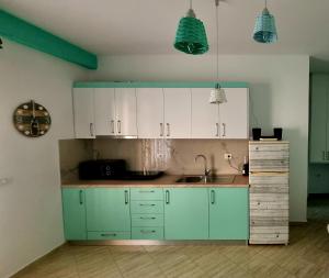 Diego Rooms Vlora في فلوره: مطبخ مع دواليب خضراء ومغسلة