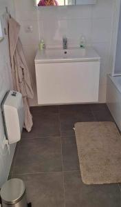 uma casa de banho com um lavatório branco e um espelho. em WH65 gezellig vakantiehuis 4pers. em Koksijde
