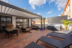 un patio al aire libre con mesa y sillas en Atico Duplex Playa Area Barcelona con SPA exterior, en Montgat