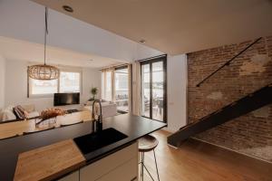 a kitchen and living room with a brick wall at Atico Duplex Playa Area Barcelona con SPA exterior in Montgat