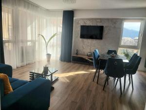 a living room with a table and a blue couch at Anastasia Luxury Apartment in Sinaia
