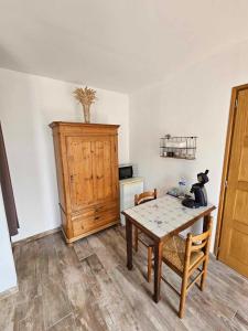 eine Küche mit einem Tisch und einem Holzschrank in der Unterkunft chambre coin nature in Fromelles