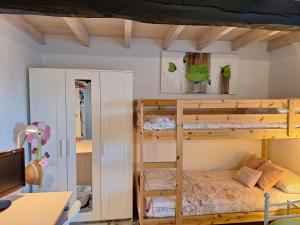 a bedroom with two bunk beds and a desk at La buganvilla en Udías in Udias