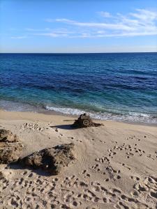 una spiaggia con impronte di piedi nella sabbia e nell'oceano di Atico Duplex Playa Area Barcelona con SPA exterior a Montgat