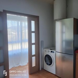 奥维塞多ALQUILER VACACIONAL PLAYA O VICEDO的厨房配有冰箱和洗衣机。