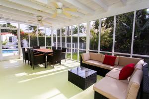 un porche cubierto con sofá y mesa en First-Class 5BR Villa in Hollywood Lakes, en Hollywood