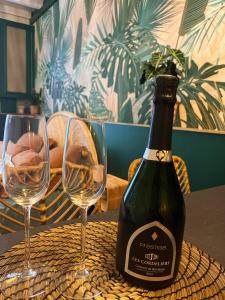 Travel Room Bordeaux : Amazo'nid : زجاجة من النبيذ وكأسين على الطاولة