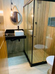 a bathroom with a shower and a sink and a mirror at Casa villa Gravatá in Gravatá