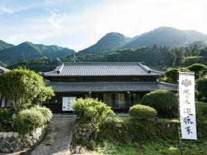 a building with a sign in front of it with mountains at Takinomoto Kondo family - Vacation STAY 30830v in Toon