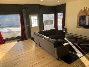 uma sala de estar com um sofá e uma televisão em Borealis Escapes Apartment 