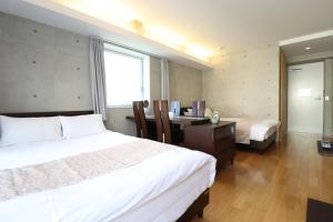 1 dormitorio con 2 camas, escritorio y ventana en Ideal Tennoji - Vacation STAY 15959, en Osaka