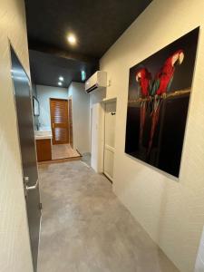 a hallway with a painting of two red parrots on the wall at JOOOOY building 2Kai - Vacation STAY 60626v in Amami