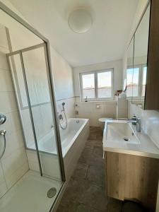 ein Badezimmer mit einer Dusche, einer Badewanne und einem Waschbecken in der Unterkunft Ferienwohnung Felderhaldeblick in Isny im Allgäu