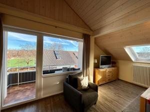 ein Wohnzimmer mit einem großen Fenster und einem Stuhl in der Unterkunft Ferienwohnung Felderhaldeblick in Isny im Allgäu