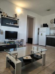 a living room with a glass table and a refrigerator at Gabriela in Nin