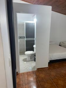 uma casa de banho com WC e uma cama num quarto em HOTEL CAMPESTRE REFUGIO TEXANO em Puerto Triunfo