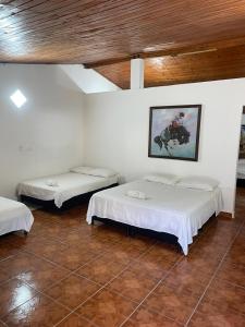 a room with two beds and a painting on the wall at HOTEL CAMPESTRE REFUGIO TEXANO in Puerto Triunfo