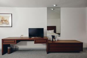 a desk with a television and a bed in a room at Hotel del Prado in Mexico City