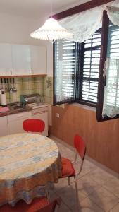 a kitchen with a table and two chairs and a table and a table at Residence Paula in Jadranovo
