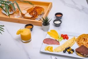 a white table with a plate of food and orange juice at Maarif elite suites in Casablanca