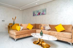 a living room with a brown couch and yellow pillows at Maarif elite suites in Casablanca
