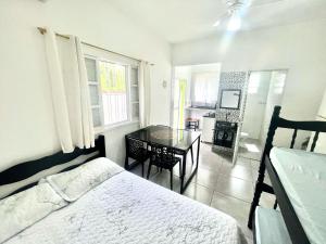 a bedroom with a bed and a dining room table at Chalé Bromélia in São Sebastião