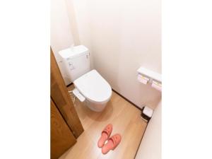 a bathroom with a toilet and a pair of pink slippers at Showa No Toraya - Vacation STAY 61491v in Chikuma