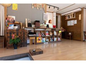 Eine Frau steht in einem Raum mit einem Buchladen in der Unterkunft Showa No Toraya - Vacation STAY 61491v in Chikuma