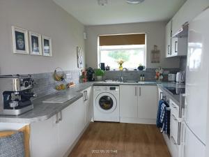 uma cozinha com um lavatório e uma máquina de lavar roupa em Harbour cottage sleeps 4 nr Marina Eastbourne em Pevensey