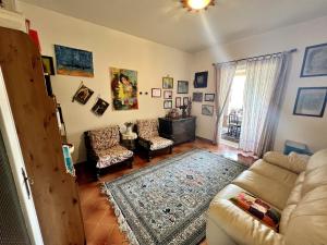 a living room with a couch and chairs and a window at La Casa Rosa in Borghetto di Vara