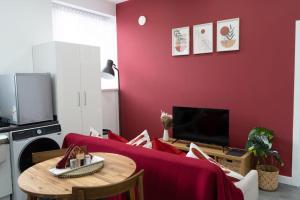 a living room with a red wall and a table at Stylish 1 bed Apartment in Newly Refurbished Building w/ Parking & Wi-Fi in Birmingham