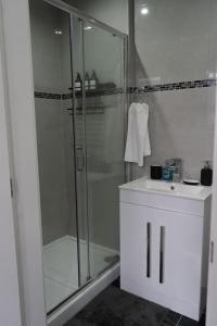 a bathroom with a glass shower and a sink at Stylish 1 bed Apartment in Newly Refurbished Building w/ Parking & Wi-Fi in Birmingham