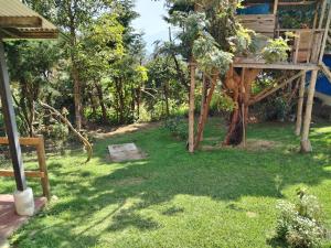 un jardín con una estructura de madera en el césped en Granja Triple A, en Guatemala