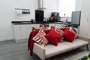 um sofá com almofadas na cozinha em Stylish 1 bed Apartment in Newly Refurbished Building w/ Parking & Wi-Fi em Birmingham