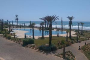 - une vue aérienne sur un parc avec des palmiers et la plage dans l'établissement Villa À louer AGLOU PLAGE TIZNIT, à Aglou