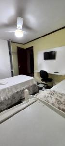 Habitación de hotel con 2 camas y TV en KzaZenDF CamaeCafé AsaSul, en Brasilia