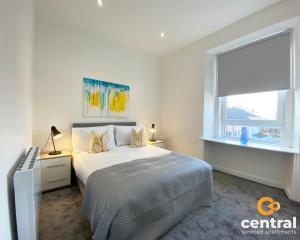 a white bedroom with a bed and a window at Lawson by CENTRAL SERVICED APARTMENTS - Cosy 1 Bedroom - Modern - Close to Transport Links - Quiet Neighbourhood - Fast WiFi - Fully Equipped - Smart TVs in All Rooms - Monthly Stays Welcome - FREE Street Parking - Ideal Relocation to Dundee Accommodation in Dundee