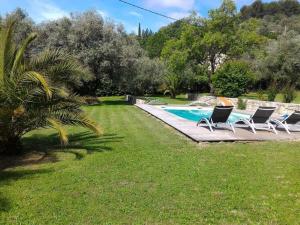 - un groupe de chaises assises à côté de la piscine dans l'établissement L'Escale Provençale, à Tourrettes